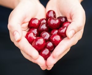 Image, handful of cherries shaped like a heart.