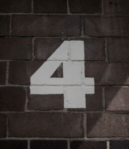 Number 4 painted in white on a brick wall