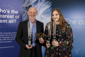 A man and woman holding three trophies and two perspex awards